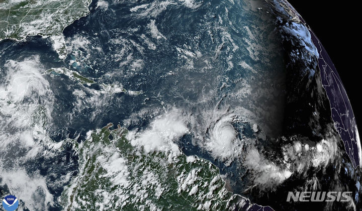 [AP/뉴시스] 미국 해양대기국(NOAA)의 29일 오후4시20분(한국시각 30일 아침5시20분) 위성사진으로 허리케인 베릴(아래 중앙오른쪽)이 카리브해로 접근하고 있다  