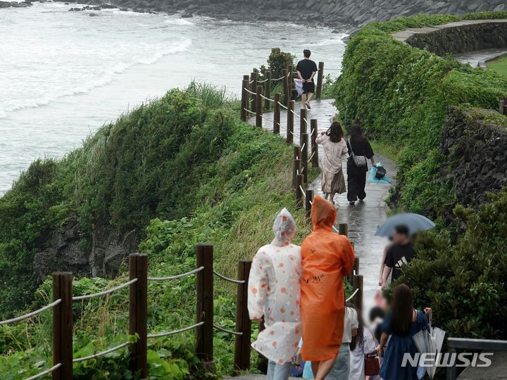  [제주=뉴시스] 오영재 기자 = 제주시 애월읍 한담공원에서 우비와 우산을 쓴 관광객들이 산책하고 있다. 2024.06.30. oyj4343@newsis.com