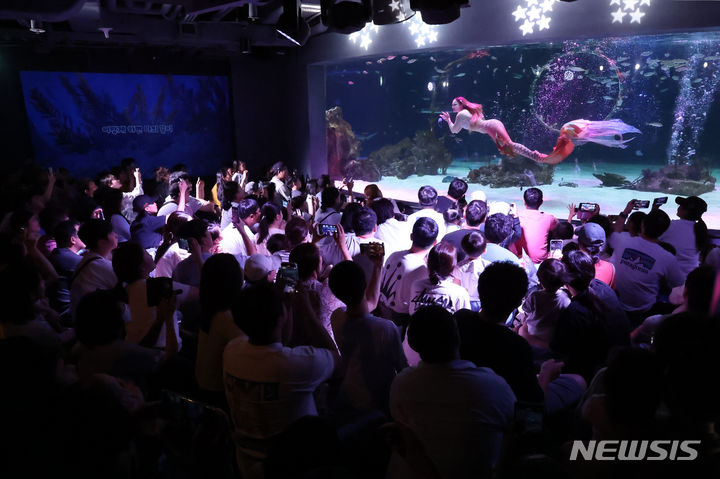 [서울=뉴시스] 김진아 기자 = '아쿠아플라넷63'과 '63아트'의 폐관일인 30일 서울 영등포구 아쿠아플라넷63을 찾은 시민들이 인어공주 공연을 감상하고 있다. 2024.06.30. bluesoda@newsis.com