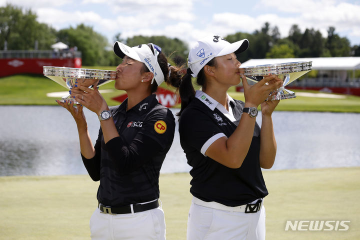 [미들랜드=AP/뉴시스] 아타야 티띠꾼(태국·왼쪽)과 인뤄닝(중국)이 1일(한국시각) 미국 미시간주 미들랜드에서 열린 미국여자프로골프(LPGA)투어 다우 챔피언십에서 우승한 뒤 트로피에 입을 맞추고 있다.