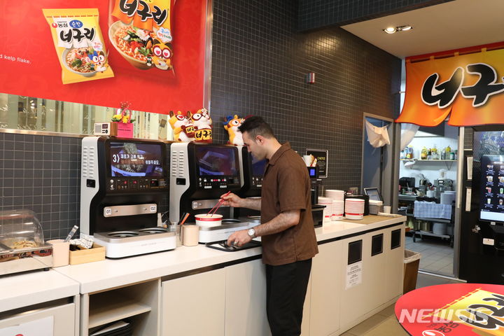[서울=뉴시스] 농심 명동 너구리의 라면가게에서 외국인이 라면을 조리하고 있다. (사진=농심 제공)