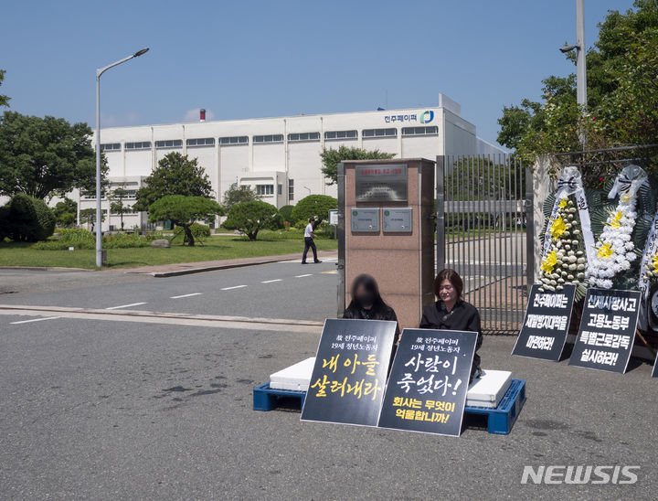 [전주=뉴시스] 강경호 기자 = 4일 전북 전주시 덕진구 팔복동 전주페이퍼 공장 정문 앞에서 전주페이퍼 사망사고 유가족들이 무기한 단식투쟁을 선언 후 정문에서 피켓을 들고 앉아있다. 2024.07.04. lukekang@newsis.com