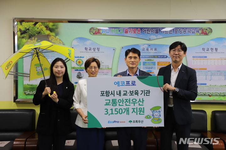 [포항=뉴시스] 송종욱 기자 = 4일 경북 포항시 송곡초등학교에서 '포항지역 아동 안전 환경 조성을 위한 교통안전 우산 전달식'이 열린 가운데 관계자들이 기념촬영을 하고 있다. (사진=에코프로 제공) 2024.07.04. photo@newsis.com