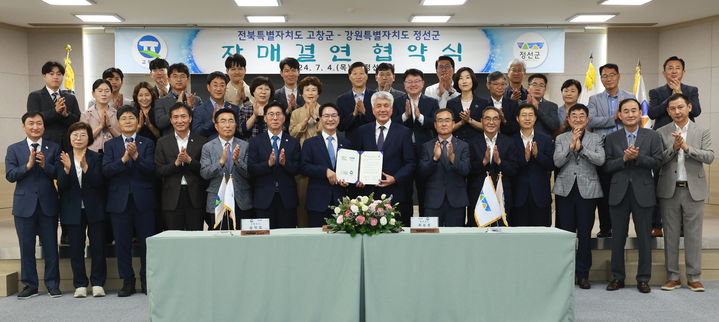 4일 정선군청에서 정선군과 전북 고창군의 상생발전을 위한 자매결연 협약식이 열렸다. 협약서를 맞든 심덕섭 고창군수(왼쪽)와 최승준 정선군수(오른쪽)를 비롯한 양 도시 관계자들이 기념사진을 찍고 있다. *재판매 및 DB 금지