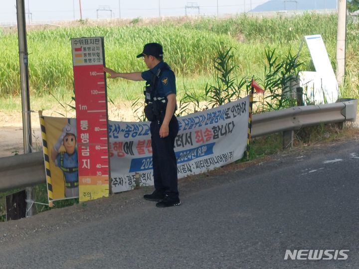 [광주=뉴시스] 집중호우를 대비해 광주 광산구 송정2교를 점검하는 광산경찰서  경찰관. (사진=광산경찰서 제공) 2024.07.05. photo@newsis.com