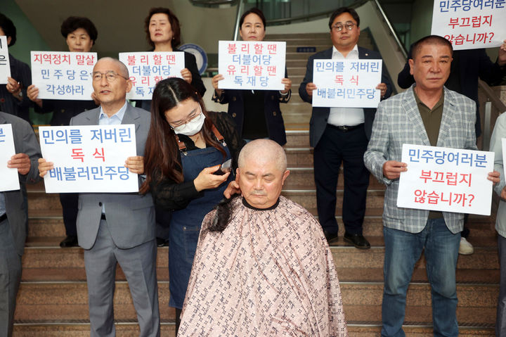 [수원=뉴시스] 5일 오전 경기 수원시청 본관 1층 로비 계단 앞에서 국민의힘 정영모 의원이 더불어민주당의 후반기 원구성 독식에 항의하기 위해 삭발식을 진행하고 있다. (사진=국민의힘 제공) 2024.07.05. photo@newsis.com  *재판매 및 DB 금지