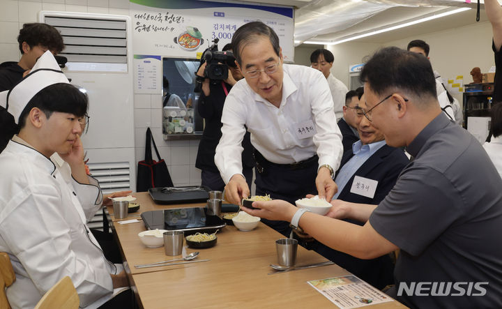 [서울=뉴시스] 추상철 기자 = 한덕수 국무총리가 7일 오전 경계선 지능 청년 상생 일터인 서울 종로구 청년밥상문간 슬로우점을 찾아 경계성 지능 청년과 보호자들을 격려한 후 식사 서빙을 하고 있다. (공동취재) 2024.07.07. photo@newsis.com