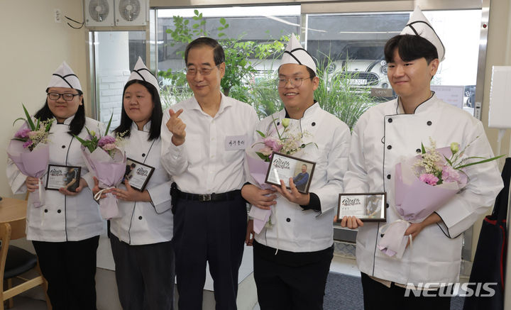 [서울=뉴시스] 추상철 기자 = 한덕수 국무총리가 7일 오전 경계선 지능 청년 상생 일터인 서울 종로구 청년밥상문간 슬로우점을 찾아 경계성 지능 청년 직원과 함께 기념촬영을 하고 있다. (공동취재) 2024.07.07. photo@newsis.com