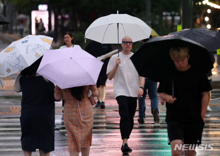 [서울=뉴시스] 김명년 기자 = 월요일인 8일은 중부지방을 중심으로 돌풍과 천둥·번개를 동반한 120㎜ 이상의 장맛비가 쏟아지겠다. 사진은 비가 내린 지난 7일 오후 서울 종로구 광화문사거리에서 우산을 쓴 시민들이 발걸음을 재촉하는 모습. 2024.07.07. kmn@newsis.com