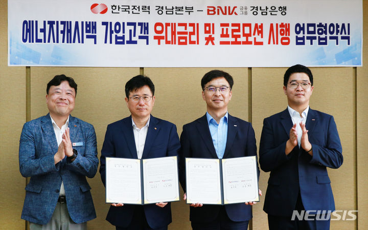 [창원=뉴시스]BNK경남은행 임재문(오른쪽서 두 번째) 상무와 한국전력공사 경남본부 김제동 본부장이 탄소중립과 에너지 절감 실천을 위한 업무협약을 체결하고 있다.(사진=BNK경남은행 제공) 2024.07.08. photo@newsis.com