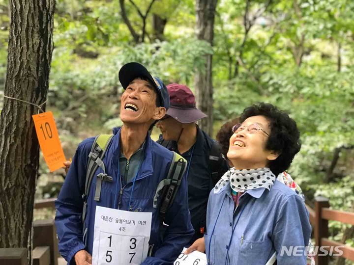 [세종=뉴시스]복권기금으로 운영되는 ‘취약계층 숲체험교육’에 참여한 참가자들이 산림 교육을 받으며 즐거워하는 모습 [사진=한국산림복지진흥원]