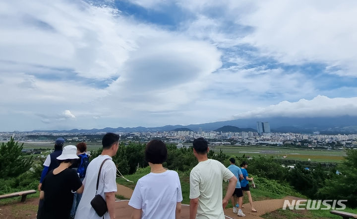 [제주=뉴시스] 우장호 기자 = 폭염과 함께 강한 바람이 불고 있는 9일 오후 제주시 도두봉에서 바라본 남쪽 하늘 위로 렌즈형 구름이 떠올라 시선을 사로 잡고 있다.렌즈구름은 강한 바람에 습한 공기가 산을 넘어가며 만들어진다. 2024.07.09. woo1223@newsis.com