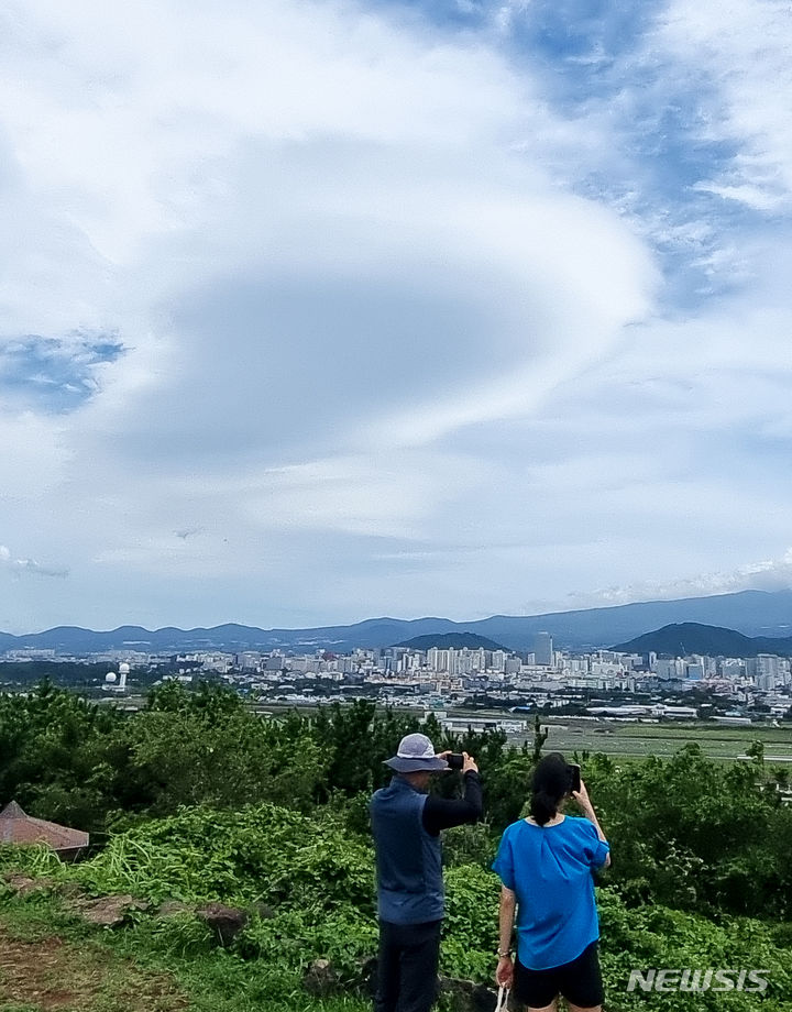 [제주=뉴시스] 우장호 기자 = 폭염과 함께 강한 바람이 불고 있는 9일 오후 제주시 도두봉에서 바라본 남쪽 하늘 위로 렌즈형 구름이 떠올라 시선을 사로 잡고 있다.렌즈구름은 강한 바람에 습한 공기가 산을 넘어가며 만들어진다. 2024.07.09. woo1223@newsis.com