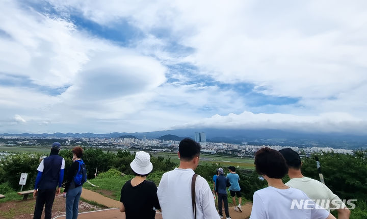 [제주=뉴시스] 우장호 기자 = 폭염과 함께 강한 바람이 불고 있는 9일 오후 제주시 도두봉에서 바라본 남쪽 하늘 위로 렌즈형 구름이 떠올라 시선을 사로 잡고 있다.렌즈구름은 강한 바람에 습한 공기가 산을 넘어가며 만들어진다. 2024.07.09. woo1223@newsis.com