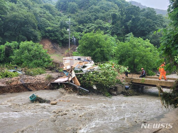 [영동=뉴시스] 서주영 기자 = 10일 오전 충북 영동군 심천면 명천리에서 저수지가 범람해 근처에 있던 주거용 컨테이너가 휩쓸렸다. (사진= 영동소방서 제공) 2024.07.10. photo@newsis.com *재판매 및 DB 금지