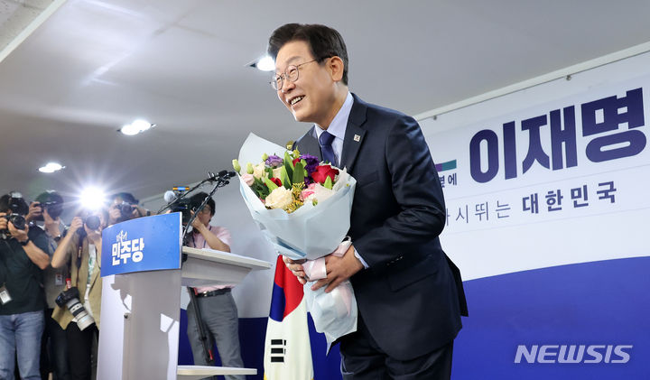 [서울=뉴시스] 조성우 기자 = 이재명 더불어민주당 전 대표가 10일 오전 서울 여의도 중앙당사에서 8·18 전당대회 당 대표 출마 선언에 앞서 지지자로부터 꽃다발을 받은 뒤 인사하고 있다. 2024.07.10. xconfind@newsis.com