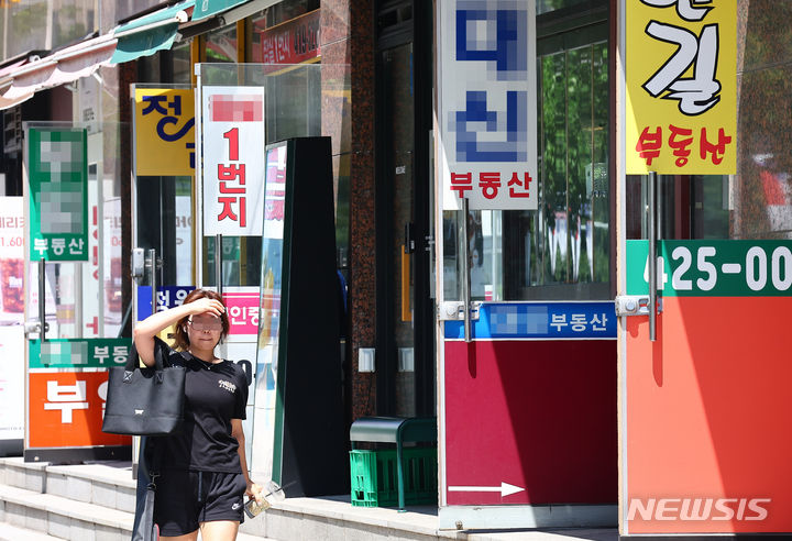 [서울=뉴시스] 김근수 기자 = 지난달 10일 서울 시내의 부동산 사무실 앞으로 시민이 지나가고 있는 모습. 2024.07.10. ks@newsis.com