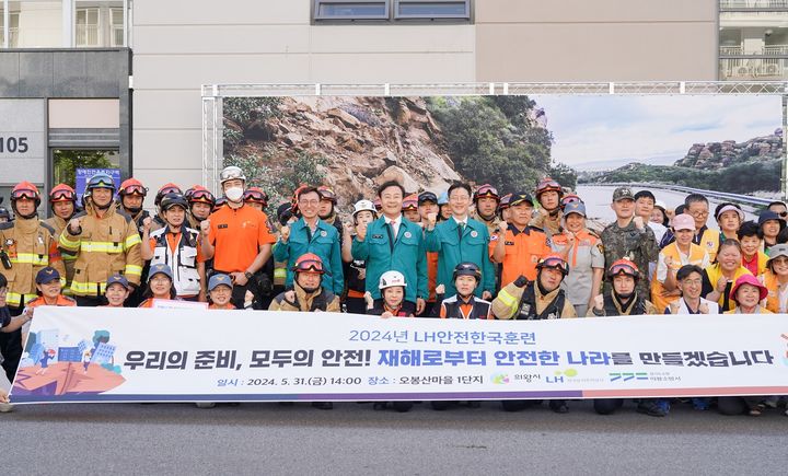 [서울=뉴시스]한국토지주택공사(LH), 의왕시, 의왕소방서, 의왕경찰서, 군부대 등 18개 민·관·공 기관 관계자들이 지난달 31일 경기도 의왕시 오봉산마을1단지 행복주택에서 '2024 재난대응 안전한국훈련' 종료 후 기념촬영을 하고 있다. (사진=LH 제공) 2024.07.11. photo@newsus.com *재판매 및 DB 금지