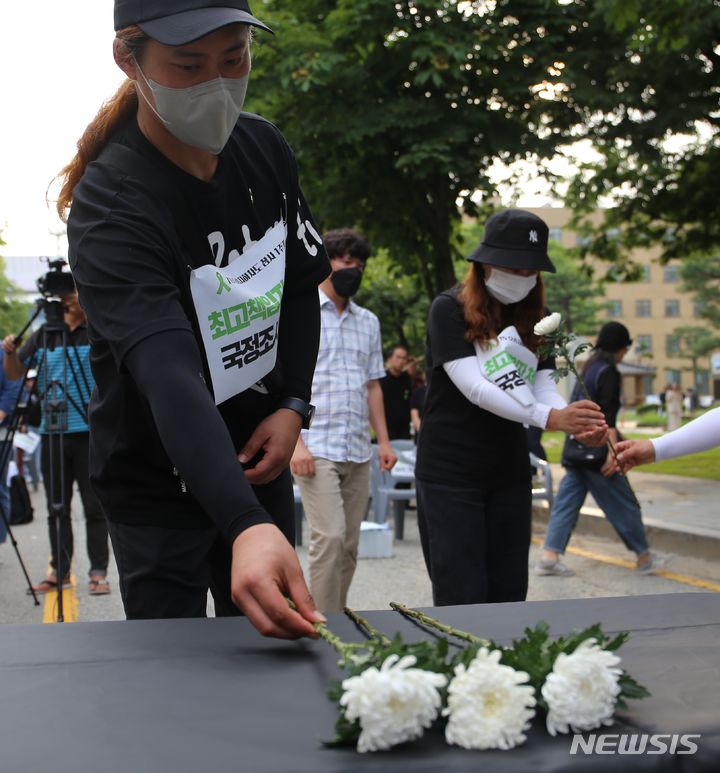 [청주=뉴시스] 서주영 기자 = 오송참사 유가족이 지난 11일 충북 도청 정문 앞에서 열린 참사 1주기 결의대회에서 희생자를 추모하는 헌화를 하고 있다. 2024.07.11. juyeong@newsis.com