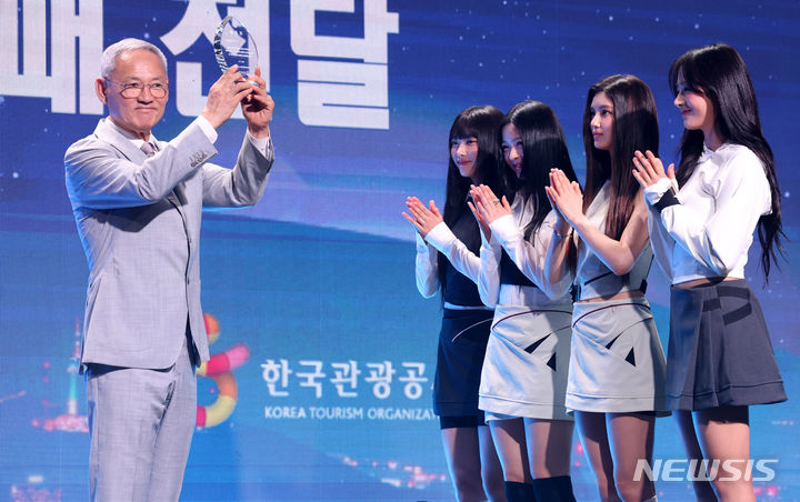 [서울=뉴시스] 추상철 기자 = 유인촌 문화체육관광부 장관이 11일 오전 서울 용산구 그랜드 하얏트 서울 그랜드볼룸에서 열린 '2024 한국 관광 명예홍보대사 위촉식'에서 명예홍보대사인 그룹 뉴진스에게 위촉패를 전달하고 있다. 2024.07.11. scchoo@newsis.com