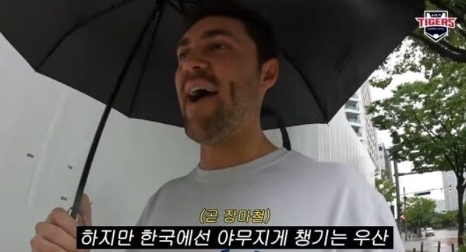 [서울=뉴시스] 같은 팀 외인 투수 캠 알드레드를 만나기 위해 숙소를 나선 네일은 비가 오자 우산을 썼다(사진= 유튜브 갈무리) *재판매 및 DB 금지