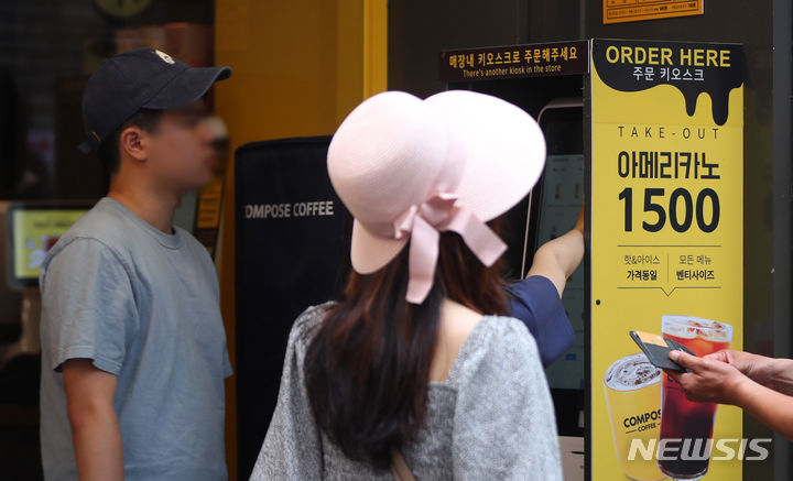 [서울=뉴시스] 김혜진 기자 = 사진은 지난 7월 12일 서울 시내 한 프랜차이즈 커피 매장에서 시민들이 키오스크로 주문하고 있는 모습. 2024.07.12. jini@newsis.com
