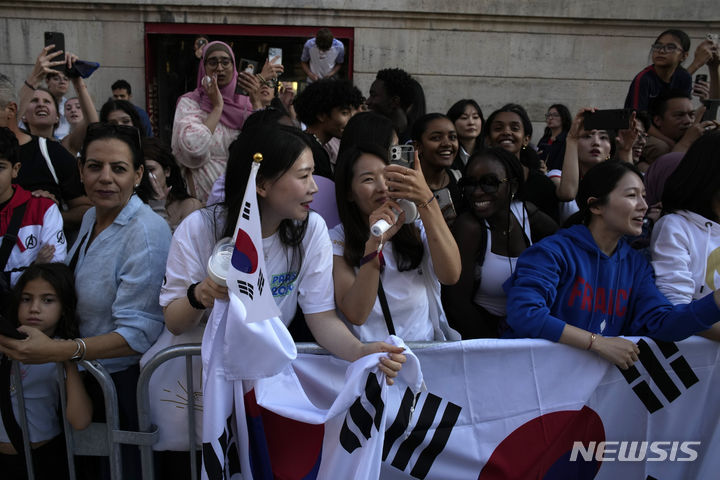 [파리=AP/뉴시스] 14일(현지시각) 프랑스 파리 루브르 박물관 인근에서 그룹 방탄소년단(BTS) 팬들이 진의 2024 파리 하계 올림픽 성화 봉송을 보기 위해 대기하고 있다. 2024.07.15.