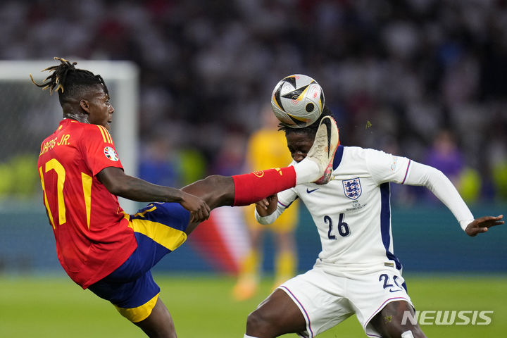 Spain's Nico Williams reaches for the ball in front of England's Kobbie Mainoo during the final match between Spain and England at the Euro 2024 soccer tournament in Berlin, Germany, Sunday, July 14, 2024. (AP Photo/Manu Fernandez)