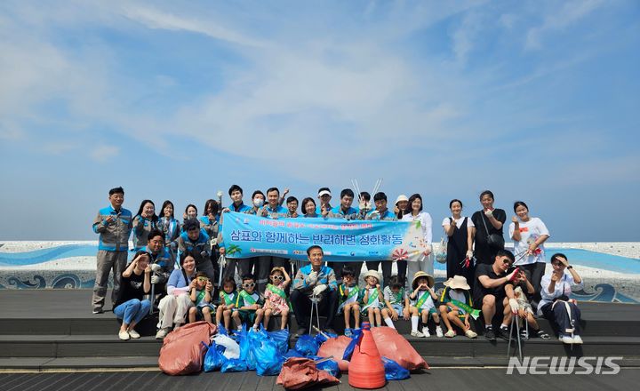 [서울=뉴시스] 삼표시멘트 임직원들이 지난 11일 삼척경찰서 직장 어린이집 아동들과 함께 반려해변인 덕산해수욕장에서 해양정화 활동을 전개한 후 기념촬영을 하고 있다. (사진=삼표그룹 제공]