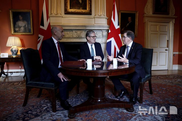 [AP/뉴시스] 2024년 7월 16일(현지 시간) 자료 사진으로, 키어 스타머 영국 총리(가운데)와 존 힐리 국방장관(왼쪽)이 나토 사무총장을 역임한 조지 로버트슨 하원의원의 말을 듣고 있다. 2026.04.15.