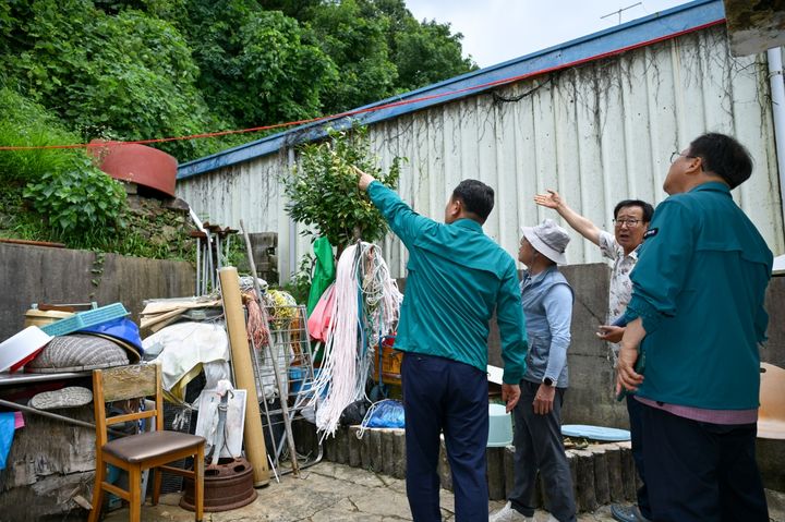 [거제=뉴시스] 신정철 기자= 박종우 거제시장(사진, 왼쪽)이 지난 15일 둔덕면 마장마을 축대 붕괴 피해 현장과 어구마을 급경사지 산사태취약지구를 방문, 주민 안전을 위한 추가 피해 대비와 재해 예방 사업의 신속한 추진을 지시했다.(사진=거제시 제공).2024.07.16. photo@newsis.com *재판매 및 DB 금지