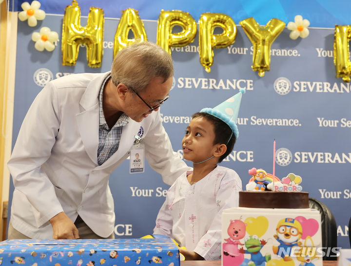 [서울=뉴시스]의료선교센터 박진용 소장이 필리핀 환아 킴에게 선물을 주고 격려하고 있다. (사진= 세브란스병원 제공) 2024.07.16. photo@newsis.com. 