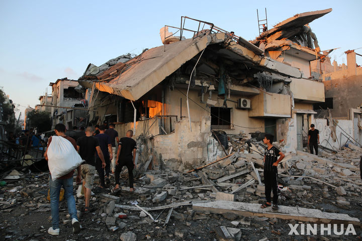 [가자지구=신화/뉴시스] 팔레스타인 가자지구 알마가지 난민촌 주민들이 이스라엘군의 공습으로 파괴된 건물 잔해를 살피고 있다. 자료사진. 2025.12.21