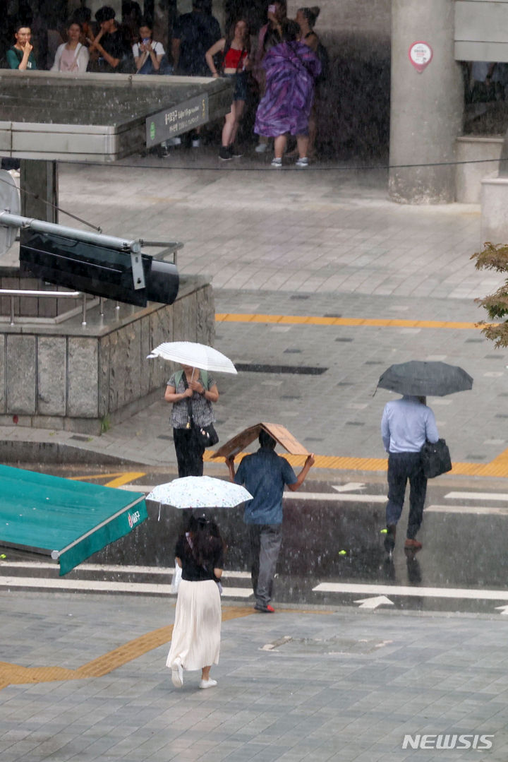 [서울=뉴시스] 홍효식 기자 = 전국적으로 장맛비가 내리는 16일 오후 서울 중구 을지로1가 사거리에서 한 시민이 우산 대신 종이박스로 비를 피하며 발걸음을 재촉하고 있다. 2024.07.16. yesphoto@newsis.com