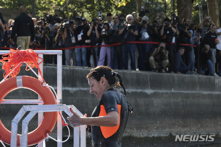 Paris Mayor Anne Hidalgo exits the Seine river after a swim, Wednesday, July 17, 2024 in Paris. After months of anticipation, Paris Mayor Anne Hidalgo took a dip in the Seine River on Wednesday, fulfilling a promise she made months ago to show the river is clean enough to host open-swimming competitions during the 2024 Olympics — and the opening ceremony on the river nine days away.(Joel Saget, Pool via AP)