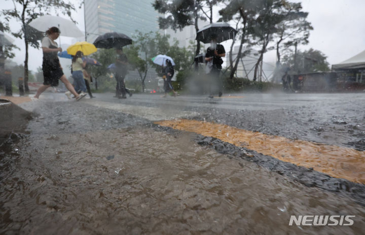 [서울=뉴시스] 황준선 기자 = 서울 전역에 호우경보가 발효된 17일 오전 서울 중구 청계광장에서 우산을 쓴 시민들이 발걸음을 재촉하고 있다. 2024.07.17. hwang@newsis.com