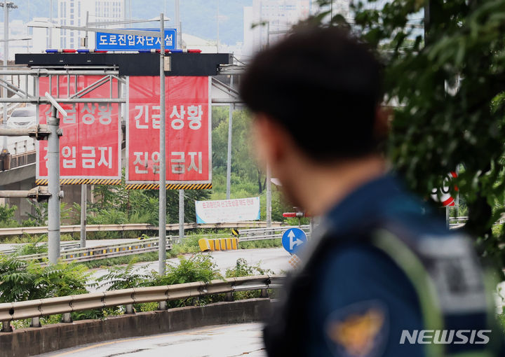 [서울=뉴시스] 김금보 기자 = 집중호우가 내린 17일 서울 성동구 성동교 부근에서 경찰이 동부간선도로 진입을 통제하고 있다.중랑천 수위가 상승하면서 동부간선도로 수락지하차도~성수JC 전 구간이 통제됐다. 2024.07.17. kgb@newsis.com