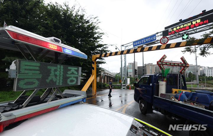 [서울=뉴시스] 김금보 기자 = 집중호우가 내린 17일 서울 성동구 성동교 부근에서 경찰이 동부간선도로 진입을 통제하고 있다.중랑천 수위가 상승하면서 동부간선도로 수락지하차도~성수JC 전 구간이 통제됐다. 2024.07.17. kgb@newsis.com