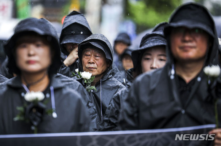 [서울=뉴시스] 정병혁 기자 = 서이초 순직교사 1주기인 18일 서울 서초구 서울서이초등학교 앞에서 전국교직원노동조합 조합원 및 시민들이 국화꽃을 들고 국회 앞까지 추모행진을 하고 있다. 2024.07.18. jhope@newsis.com