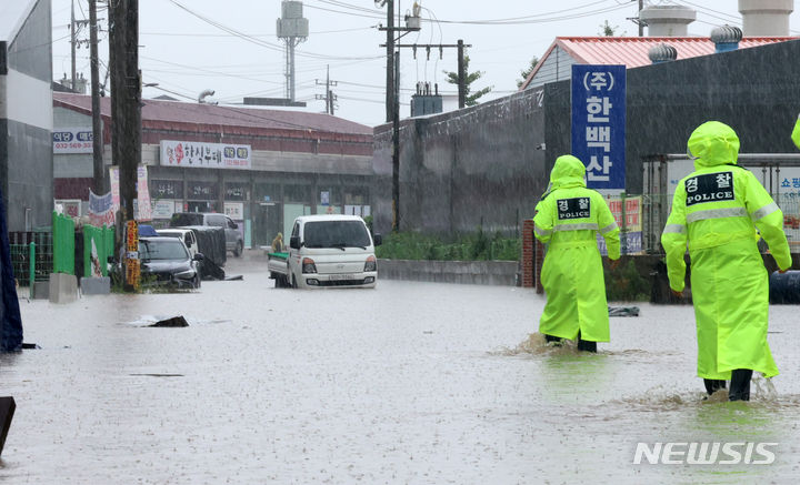 [인천=뉴시스] 전진환 기자 = 수도권 일대에 이틀째 폭우가 쏟아지는 가운데 18일 오전 인천 서구 사월마을에서 경찰이 물에 잠긴 공장지대를 수색하고 있다.  2024.07.18. amin2@newsis.com