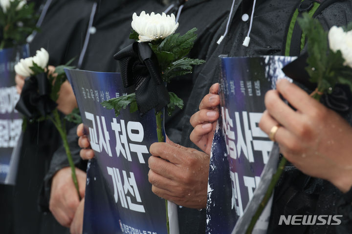 [서울=뉴시스] 조성봉 기자 = 지난 18일 오후 서울 여의도 국회 본청 계단에서 열린 '공교육 정상화 특별법 제정 촉구, 순직교사 1주기 전교조 추모기자회견'에서 참석자들이 국화와 손피켓을 들고 있다. 2024.07.23 suncho21@newsis.com