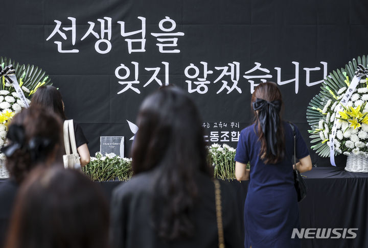 [서울=뉴시스] 정병혁 기자 = 서이초 순직교사 1주기인 18일 서울 서초구 서울교육대학교에서 열린 교사유가족협의회, 초등교사노동조합 2024 순직교사 추모행사를 찾은 교사 및 시민들이 헌화를 하고 있다. 2024.07.18. jhope@newsis.com