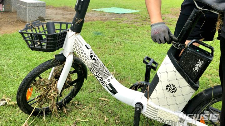 [오산=뉴시스] 업체관계자가 침수된 대여용 전기자전거를 수거하고 있다.