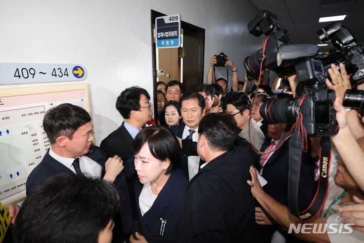 [서울=뉴시스] 권창회 기자 = 정청래 국회 법사위원장이 19일 서울 여의도 국회에서 열린 제3차 법제사법위원회 윤석열 대통령 탄핵소추안 즉각 발의 요청에 관한 청원 관련 청문회에서 추경호 국민의힘 원내대표를 비롯한 국민의힘 의원들에게 항의를 받으며 입장하고 있다.  2024.07.19. kch0523@newsis.com