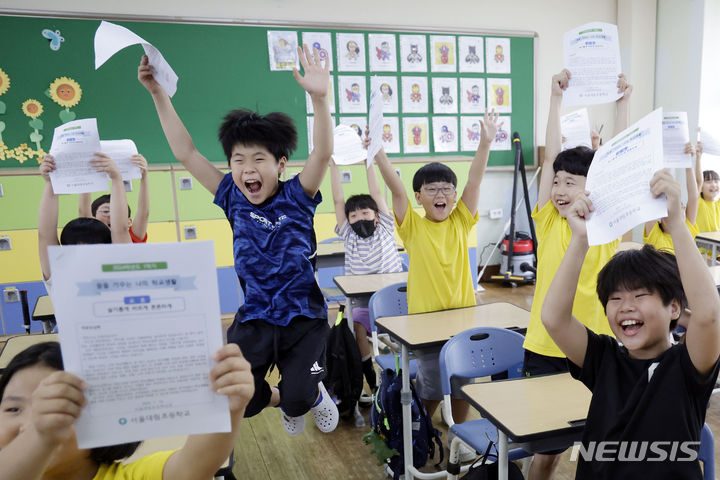 [서울=뉴시스] 최동준 기자 = 19일 서울 동작구 대림초등학교에서 4학년 5반 학생들이 여름방학식 중 학교생활통지표를 들어보이며 즐거워하고 있다. 2024.07.19. photocdj@newsis.com