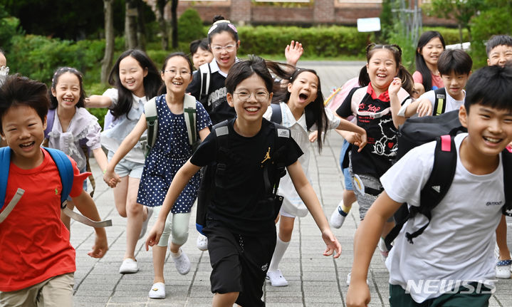 [수원=뉴시스] 김종택 기자 = 19일 경기도 수원시 영통구 신성초등학교에서 3학년2반 학생들이 여름 방학식을 마치고 밝게 웃으며 하교하고 있다. 2024.07.19. jtk@newsis.com