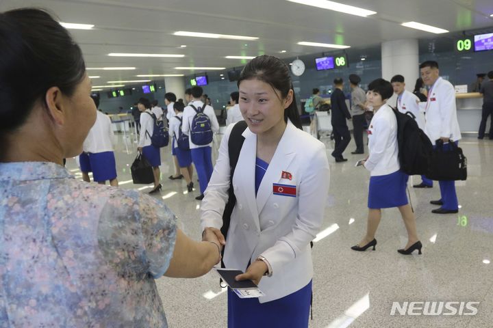 [평양=AP/뉴시스] 2024 파리 올림픽에 출전하는 북한 선수단 관계자가 20일 오전 평양 순안 국제공항을 통해 출국하기 전 지인과 인사를 나누고 있다. 2024.07.20