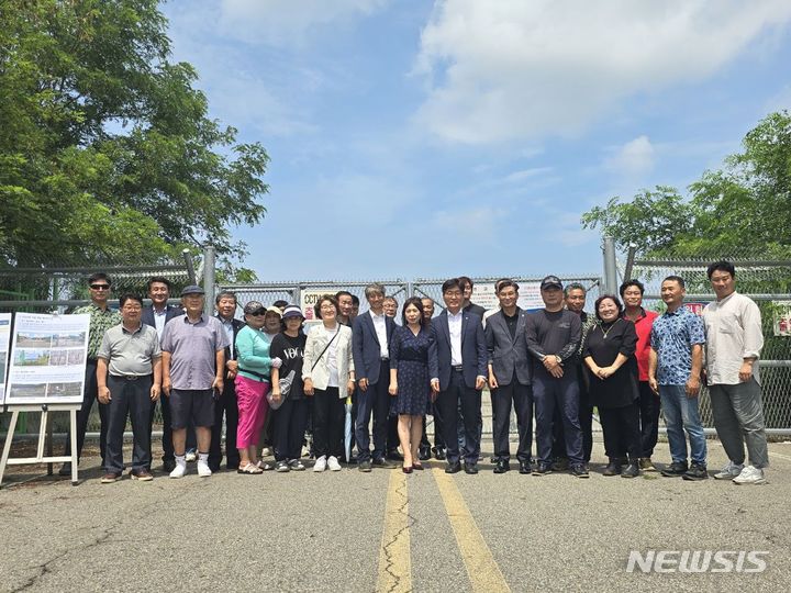 [안산=뉴시스] 박해철 국회의원이 19일 안산 방아머리 소재 시화방조제 미개통도로 입구에서 '시화방조제 유지관리통로 이용방법 개선 설명회'에서 주민들에게 개방 관련 소식을 전하고 함께 기념촬영을 하고 있다.(사진=박해철 의원실 제공)2024.07.20.photo@newsis.com