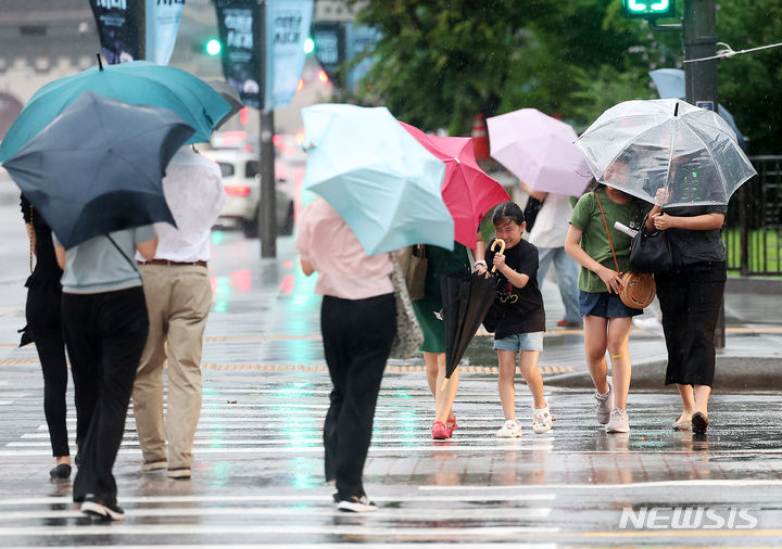 [서울=뉴시스] 김명년 기자 = 비가 내린 지난 20일 오후 서울 종로구 광화문 사거리에서 우산을 쓴 시민들이 발걸음을 재촉하고 있다. 2024.07.20. kmn@newsis.com