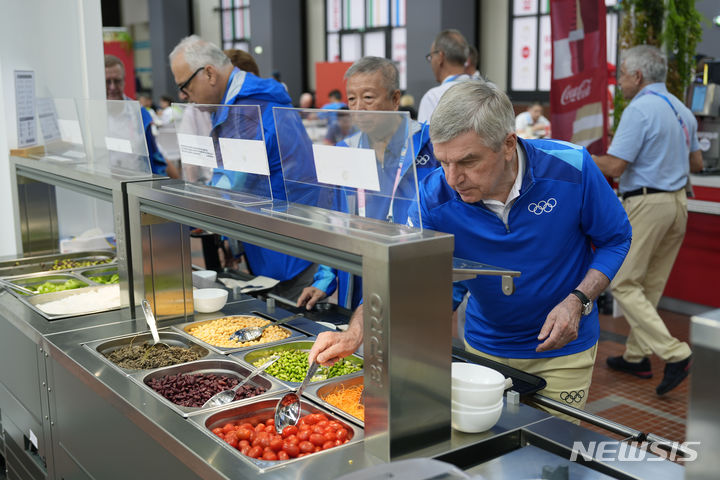 [파리=AP/뉴시스] 토마스 바흐 국제올림픽위원회(IOC) 회장이 지난달 22일 '2024 파리 올림픽' 선수촌 내 설치된 식당에서 음식을 담고 있다. 2024.07.22.